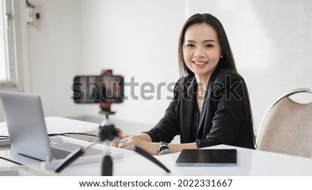 Stock photo of a Southeast Asian Ethnic business woman student teacher tutor video conference calling on laptop computer talk by webcam learn teach in online chat, distance online teaching concept