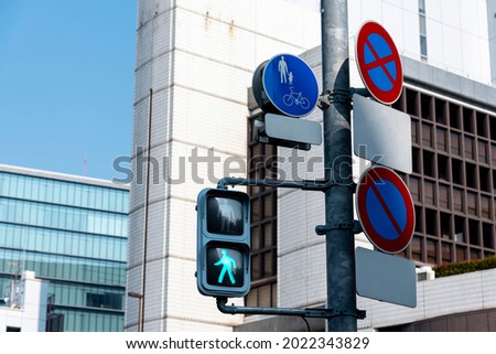 crosswalk traffic lights and traffic sign with building background in tokyo, japan