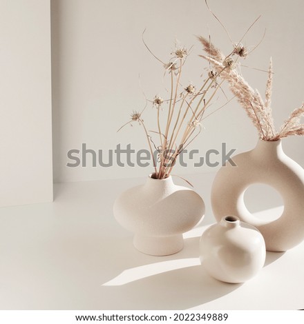 Modern beige ceramic vase set with dry  grass and sunlight shadow on white table top view.Copy space,  Scandinavian interior accessories.  Royalty-Free Stock Photo #2022349889