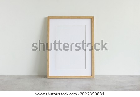 Frame mockup template on white wall  background on gray concrete desk. Copy space. Minimal concept. Interior wall accessories photo frame, poster.