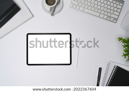 Top view digital tablet with empty display and stylus pen on white office desk.