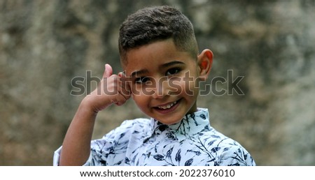 Brazilian small boy giving thumbs up. Hispanic child gives positive signal