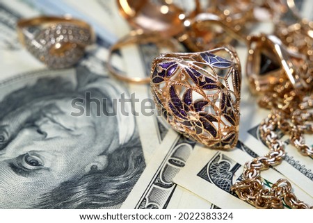 money and jewelry, pawn shop and buy and sell golden rings, necklace bracelet o wooden background, closeup Royalty-Free Stock Photo #2022383324