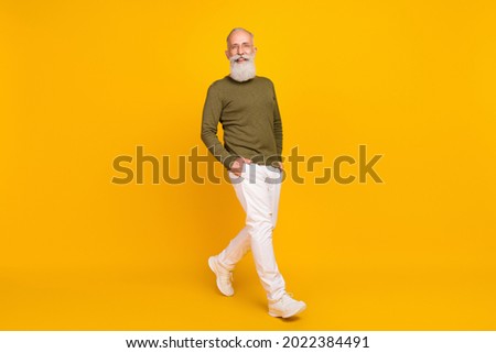 Photo of candid retired man enjoy stroll wear specs green shirt trousers footwear isolated yellow color background