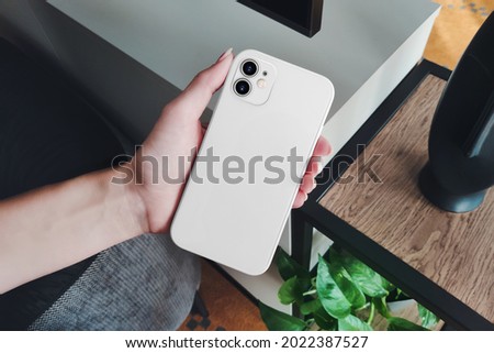 Phone in case in the hand of a girl mockup Royalty-Free Stock Photo #2022387527