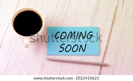 COMING SOON text on blue sticker with cofee and pen