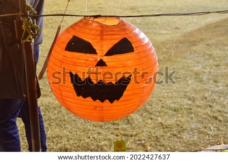 a jack o lantern chinese lantern hung on a rope