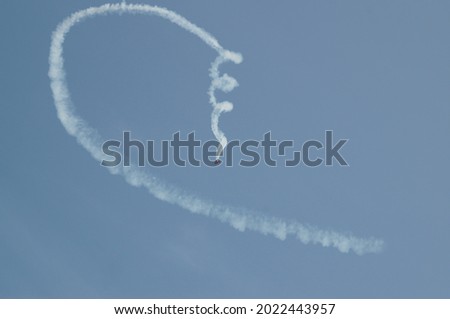A photo of the smoke trail left by a aeroplane performing an acrobatic loop into a spin