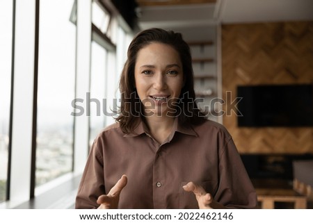 Positive engaged business woman looking at camera, speaking, smiling. Female coach, teacher talking to audience from screen, giving webinar, workshop via conference video call. Head shot portrait Royalty-Free Stock Photo #2022462146