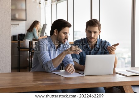 Office employees discussing project at laptop, sharing ideas. Mentor training intern skills, explaining work process. Manager showing presentation to client. Business meeting, internship concept Royalty-Free Stock Photo #2022462209