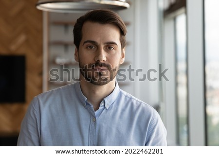 Portrait of serious confident businessman, entrepreneur, company leader, employee. Head shot of millennial 30s bearded man in casual shirt looking at camera. Business profile picture