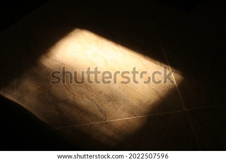 Light gazes upon the rough marble floor from barring curtain and liberal window. The reality of this picture shows how many things are lit up yet are surrounded by darkness.