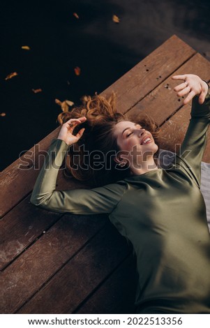 Young beautiful woman lying by the lake