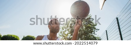 African american man holding basketball ball outdoors, banner
