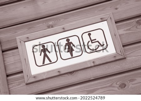 Lady and Gentleman Toilet Sign with Wooden Background in Black and White Sepia Tone