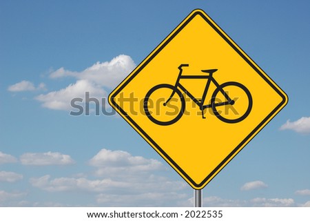 Bicycles ahead warning sign with clouds in the background