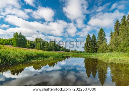 Panoramic landscape of a calm river.A mirror image of Clouds and forests On the Lake.