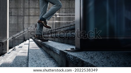 Motivation and challenging Concept. Steps Forward into a Success. Low Section of Businessman Walking Up on Staircase. City Scene Royalty-Free Stock Photo #2022538349