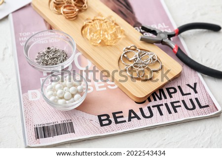 Workplace of jewelry designer with  tools and beads on table