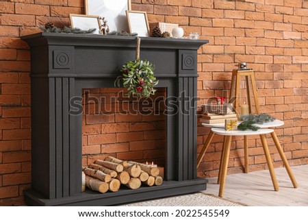 Mistletoe branch on fireplace against brick wall