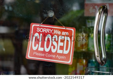 A closed sign hanging inside a shop door                               