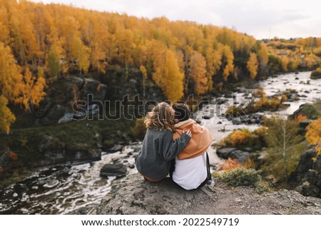 A happy couple in love in casual clothes travel together, hike and have fun in the fall forest on a weekend in nature in autumn outdoors, selective focus