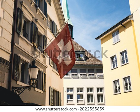 swiss flag in zurich city centre with old buildings - swiss flag in switzerland old town