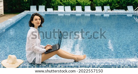 freelancer or blogger girl works online near the hotel's swimming pool. Vacation and remote work millennial. Distance freelance or webcam training webinar. Banner and place for text High quality photo