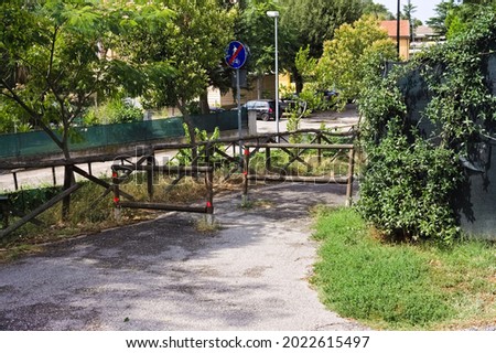 Wooden barriers with a road sign indicating the end of the pedestrian path (Marche, Italy, Europe)