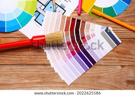 Color palettes with paint brush and building plan on wooden background