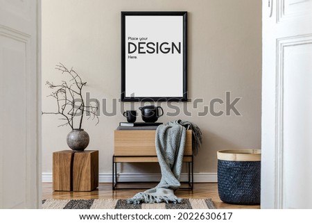 Design scandinavian home interior of living room with mock up poster frame, stylish wooden commode, cube, flower in vase and elegant accessories. Beige wall. Modern home staging. Template.
