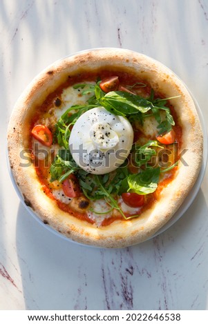 Buratta cheese on a neapolitan pizza on a cafe table