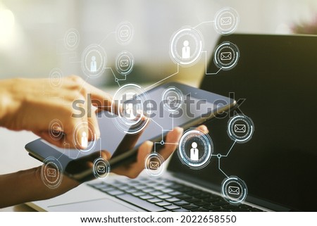 Double exposure of social network icons concept and hand working with a digital tablet on background. Networking concept