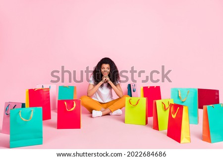 Photo of shiny dreamy dark skin lady wear white t-shirt sitting floor looking many shopping bags isolated pink color background
