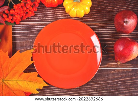 Composition with pumpkin, autumn leaves, plate and red pears. Cozy autumn mood concept. Top view. Copy space.