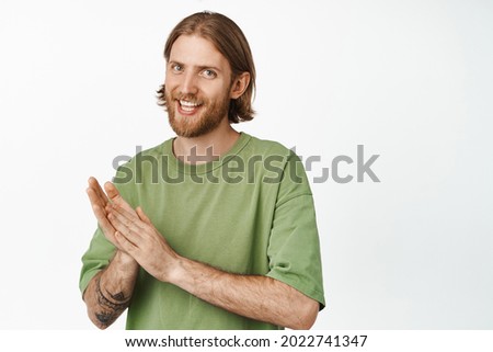 Pleased blond bearded man rub hands and smiling cunning, relish good income, going to receive something, expecting smth positive happen, white background Royalty-Free Stock Photo #2022741347
