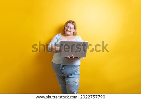 fat young caucasian model holding laptop. plus size. blogging