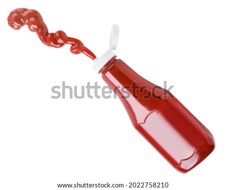 Ketchup flies out of a bottle close-up on a white background, cut. Isolated Royalty-Free Stock Photo #2022758210