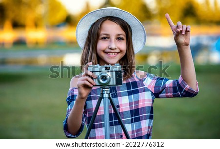 Young photographer. Little girl making a photo with vintage photo camera