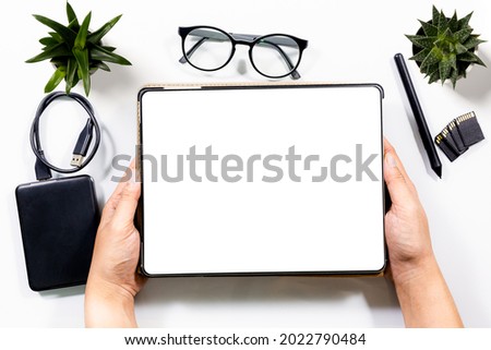 Tablets and envelopes are on the desk,Flatlay digital tablet blank screen on work desk with glasses and coffee