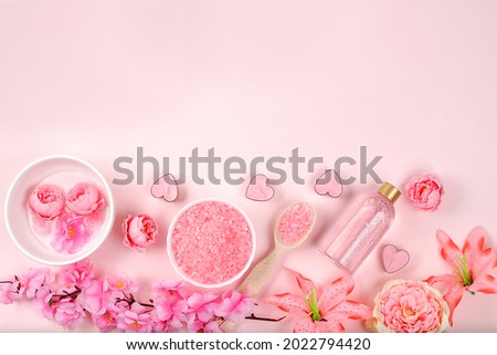 Spa ingredients with fragrant rose water, sea salt, rose and sakura flowers, skin and body care, aromatherapy, lifestyle concept, card for invitation and advertising, place for text, selective focus,