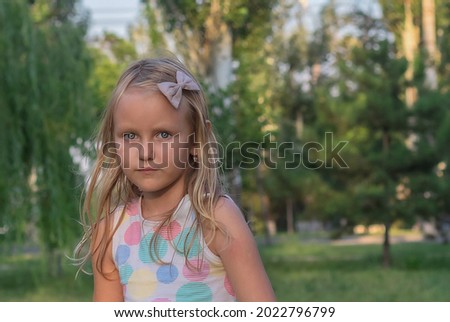 girl 6-7 years old with long blond hair stands against the background of nature, portrait of a child, cute girly, preschooler, in the park