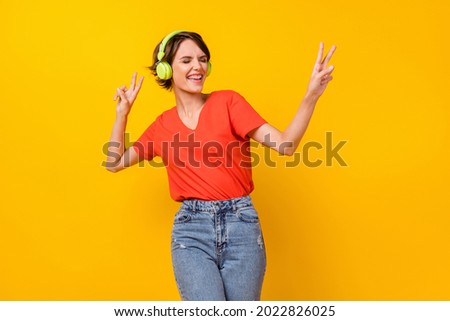 Photo of nice brunette optimistic lady dance listen music wear headphones red t-shirt isolated on vivid yellow color background