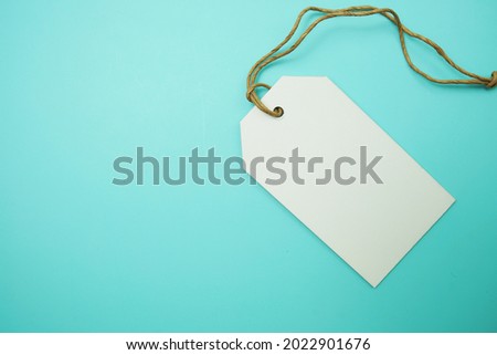 Flat lay White Blank Tag on blue background