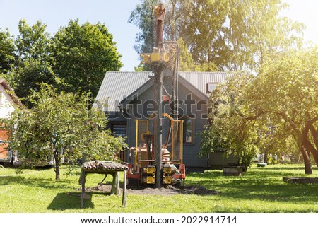 Drilling in ground an artesian well for groundwater. Mud shooting out of tube. Clean water supply. Royalty-Free Stock Photo #2022914714