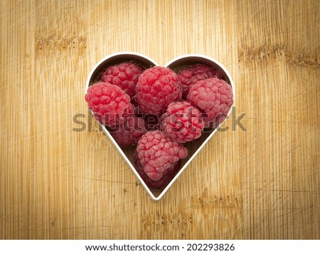 fresh ripe organic raspberries in heart shape