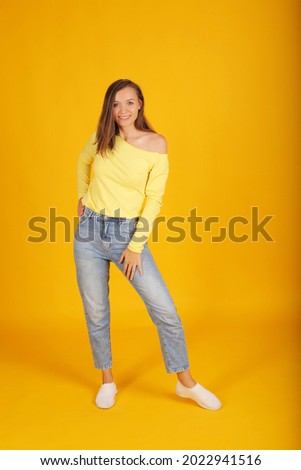 a young beautiful blonde girl in a yellow jacket and jeans holds a pose in full-length movement