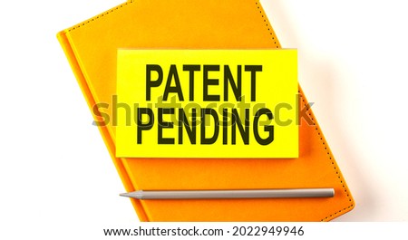 Text PATENT PENDING on the sticker on yellow notebook