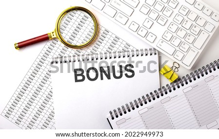 BONUS text written on notebook on chart with keyboard and planning