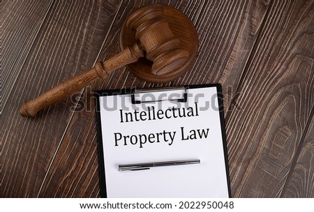 INTELLECTUAL PROPERTY LAW text on paper with gavel on wooden background